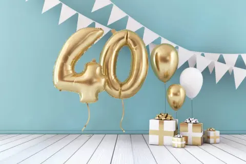 Złote balony z cyfrą 40, prezenty i girlanda tworzą idealną scenografię na wierszyk na 40 urodziny.