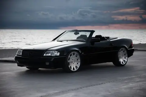 Svart cabriolet vid havet, en dröm om en skattebefriad bil som väntar på en solig dag.