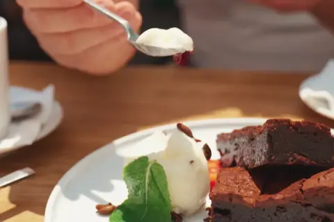 Słodki deser z brownie i lodami, serwowany w pomelo bistro. Idealny na popołudniową kawę.