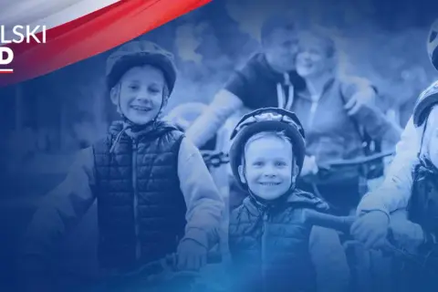 Uśmiechnięte dzieci w kaskach na rowerach, symbolizujące radość i wsparcie dla rodzin w ramach programu Polski Ład.
