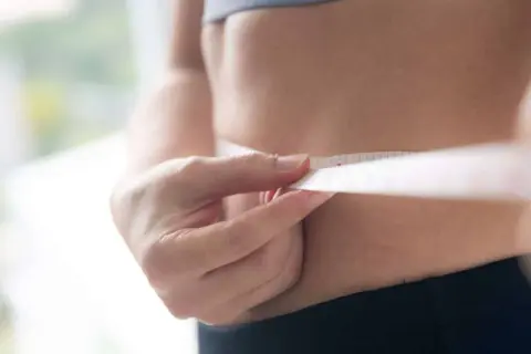Misura della vita con metro, per capire quante calorie bisogna bruciare al giorno per raggiungere i propri obiettivi di benessere.