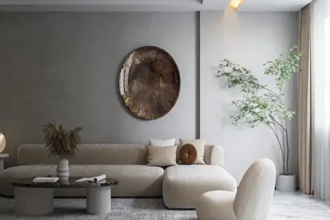 Salon w stylu japońskim skandynawskim. Jasna sofa, okrągły stolik, dekoracyjna taca na ścianie i drzewko bonsai tworzą harmonię.