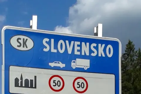 Granica Słowacji. Znak informuje o ograniczeniu prędkości do 50 km/h. Warto sprawdzić, ile kosztuje winieta na Słowacji przed podróżą.