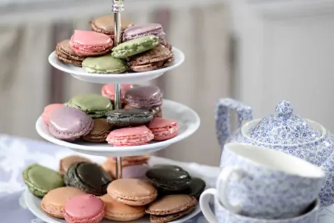 Färgglada macarons på ett tårtfat, redo att avnjutas. Ett perfekt macarons recept för fika.