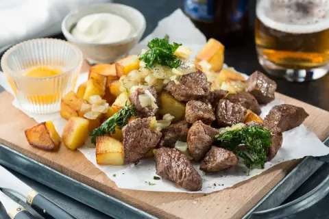 Biff Rydberg-inspirerad rätt med tärnad biff, stekt potatis, lök och en skål med sås. Ett perfekt biff rydberg recept för en härlig middag.