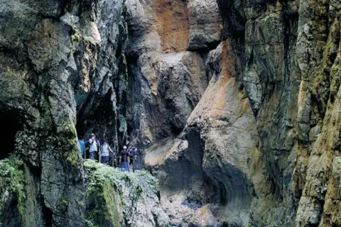 Wanderer erkunden die beeindruckende Klamm Garmisch mit ihren steilen Felswänden und moosbewachsenen Gängen.