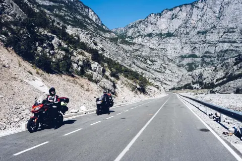 Motocykliści jadący krętą drogą przez skaliste góry w Albanii.