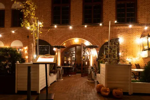 Restauracja Filharmonia zaprasza do swojego przytulnego ogródka. Menu na stojaku, dynie i ciepłe światła tworzą jesienny klimat.