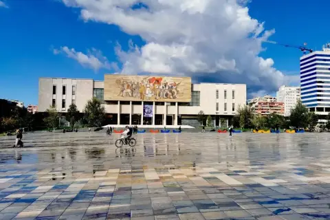 Plac Skanderbega, serce stolicy Albanii, z monumentalnym budynkiem i mozaiką.