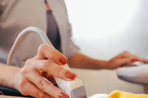 Dłoń trzymająca głowicę USG. Czy można pomylić chłopca z dziewczynką na USG? To pytanie nurtuje wielu rodziców.