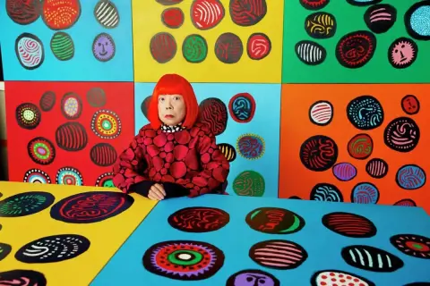 Yayoi Kusama w otoczeniu swoich kolorowych dzieł, pełnych kropek i wirów.