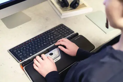 Mains sur un clavier et une souris ergonomique, des pointeurs de souris pour un confort optimal.