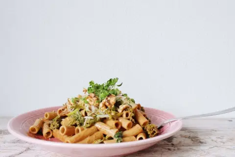En läcker vegetarisk pasta med broccoli och valnötter, toppad med färska örter.