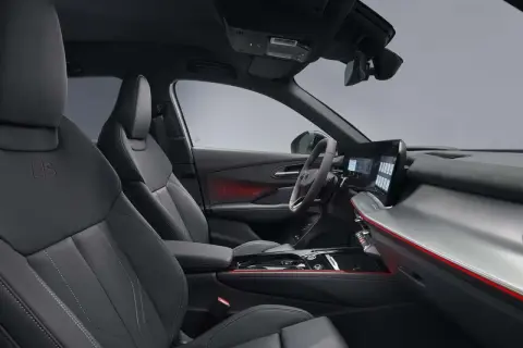 Interni sportivi dell'Audi Q3 Sportback: sedili in pelle nera, illuminazione d'ambiente rossa e un moderno cruscotto digitale.