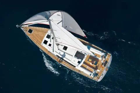 Vela genoa spiegata su un elegante yacht che solca il mare blu.