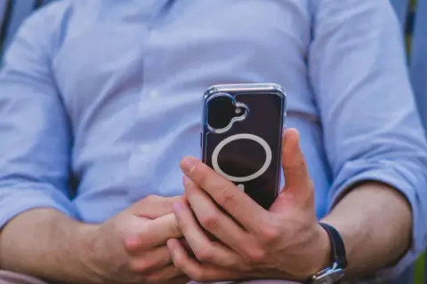 Mężczyzna trzyma telefon, który może wysyłać sygnały haptyczne.