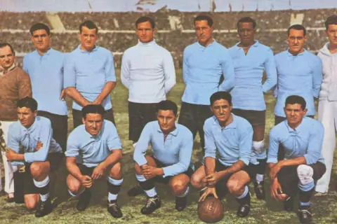 Equipo de Uruguay posa antes del primer mundial de futbol. Jugadores con camisetas celestes y un entrenador.