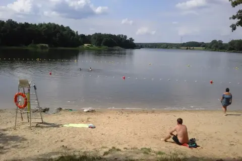 Słoneczny dzień nad zalewem Rybnik. Kąpielisko z ratownikiem, plażą i ludźmi kąpiącymi się w wodzie.