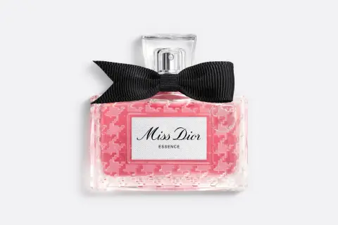 Różowy flakonik Miss Dior Essence z czarną kokardką, pachnący jak soczysta wiśnia.