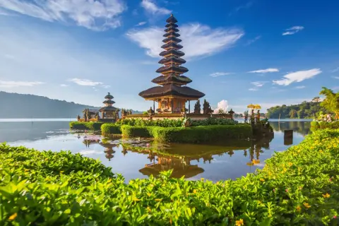 Świątynia Pura Ulun Danu Bratan na Bali, jaki to kraj! Woda odbija wielopoziomową wieżę na tle błękitnego nieba.