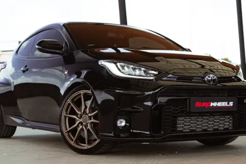 Czarny Toyota Yaris Sport z brązowymi felgami, gotowy do dynamicznej jazdy.