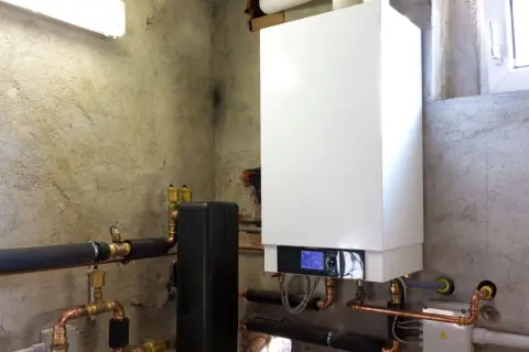 Installazione di una moderna caldaia a condensazione con tubature in rame e isolamento termico.