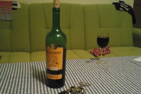 Butelka Kadarka na stole, obok kieliszek z winem. Zastanawiam się, kadarka ile procent ma w sobie?