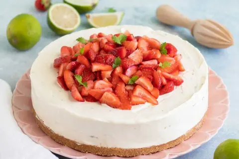 En krämig vit choklad cheesecake toppad med färska jordgubbar och mynta. En perfekt sommardessert!