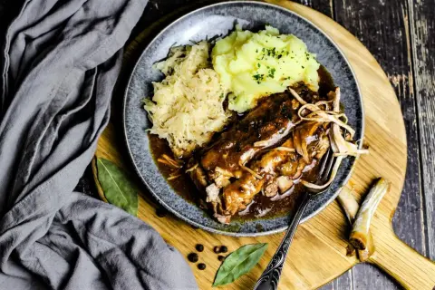 Herzhaftes Gericht mit Rippchen, Sauerkraut und Kartoffelpüree, serviert auf einem Teller. Perfekt für einen gemütlichen Abend.