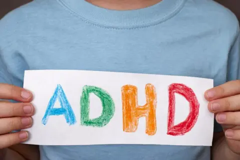 Dziecko trzyma kartkę z napisem ADHD. Czy medikinet ma skutki uboczne?