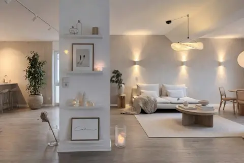 Idee per come abbellire un pilastro in soggiorno: mensole con quadri, candele e decorazioni.
