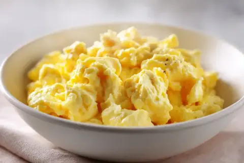 En skål med fluffiga, gyllene äggröra, perfekt för en god frukost.