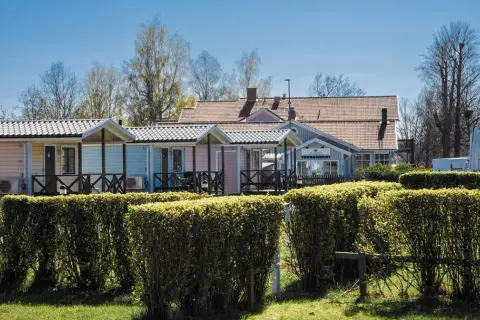 Färgglada stugor och reception vid Villa Björkhagen, Jönköping. En husbil syns till höger.