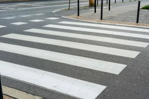 Lignes blanches sur l'asphalte, un passage piéton invite à traverser la rue en toute sécurité.