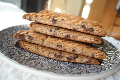 En stapel hembakade kolasnittar med choklad, redo att avnjutas.