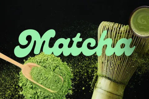 Poudre de matcha verte, cuillère en bois, fouet et tasse de boisson, évoquant le goût matcha authentique.