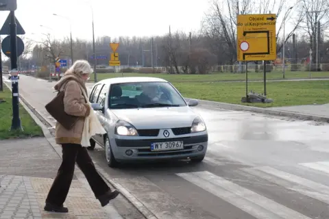 Kobieta na pasach, samochód zbliża się. Kto ma pierwszeństwo na parkingu pieszy czy samochód? Pieszy!