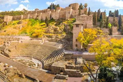 Vestiges d'un théâtre romain et de l'Alcazaba, un site historique à visiter à Malaga, sous un ciel bleu éclatant.