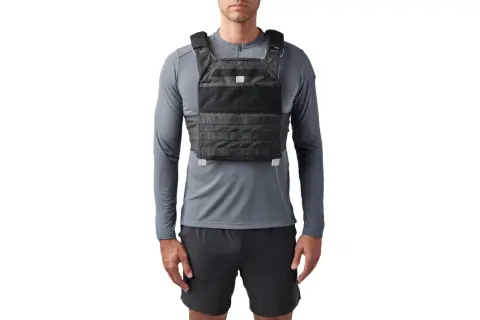 Mann trägt eine 5.11 Gewichtsweste über einem grauen Langarmshirt und schwarzen Shorts.