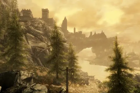 Majestatyczny krajobraz Skyrim z zamkiem na wzgórzu i łukiem skalnym. Idealny do sprawdzenia wymagań sprzętowych gry.