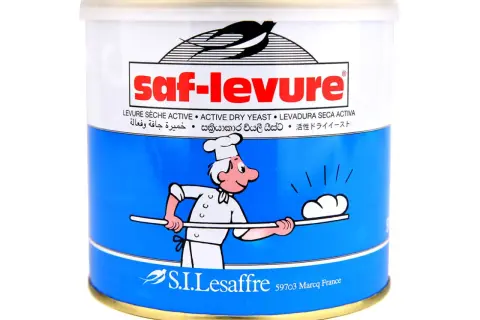 Boîte de levure boulangère déshydratée Saf-Levure, avec un dessin de boulanger souriant.