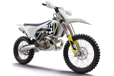 Nowy motocykl cross Husqvarna 250 gotowy na wyzwania toru. Biało-niebiesko-żółte malowanie, potężny silnik i terenowe opony.