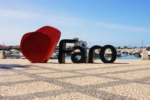 Serce i napis FARO na brukowanym placu przy marinie, tuż obok lotniska Algarve.