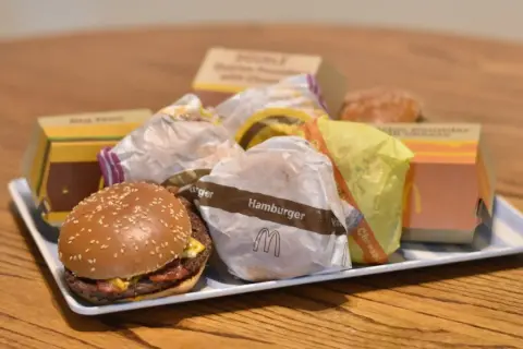 Taca pełna hamburgerów z McDonald's. Widać opakowania Big Mac, McRoyal i inne.