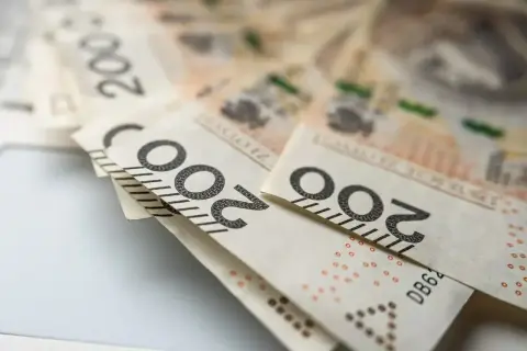 Polskie banknoty 200 zł leżące na jasnym tle.