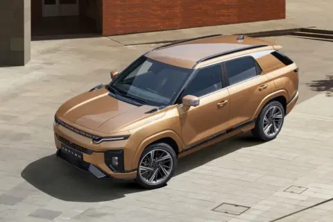 Złoty SUV z rodziny koreańskie marki aut, z nowoczesnym designem i eleganckimi felgami, zaparkowany na placu.