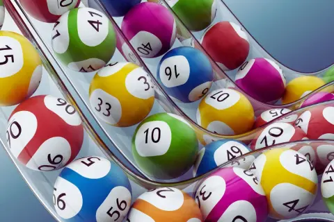 Kolorowe kule lotto wpadają do maszyny. Czy nagroda w loterii pożyczkowej jest zwolniona z podatku od wzbogacenia?