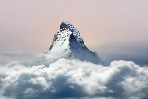 Majestätisches Matterhorn Nordwand ragt aus Wolken empor, ein eisiger Gigant im sanften Licht des Himmels.