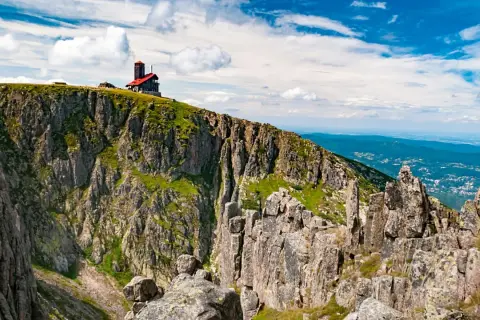 Szrenica góruje nad Śnieżnymi Kotłami, gdzie skalne urwiska i zielone zbocza tworzą majestatyczny krajobraz.