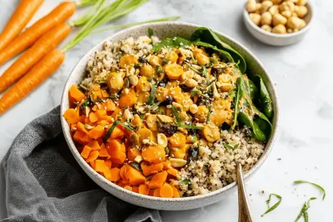 Bunter Quinoa-Bowl mit Karottenwürfeln, Kichererbsen und Nüssen. Ein leckeres Beispiel für Karotten Rezepte.